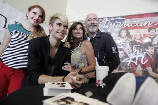 Colton Dixon signs autographs while his family looks on.